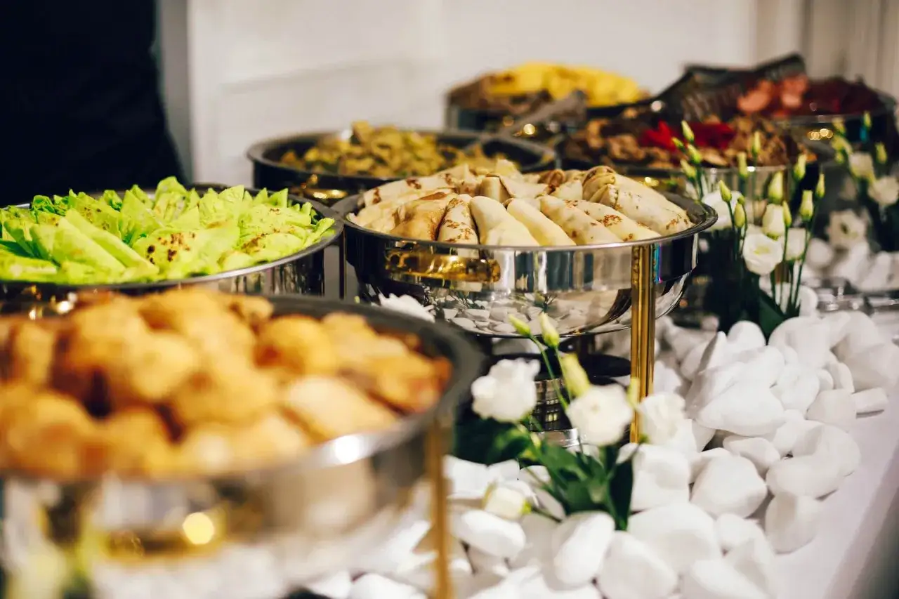 Młodzi ludzie planujący imprezę urodzinową, kalkulator, menu cateringowe